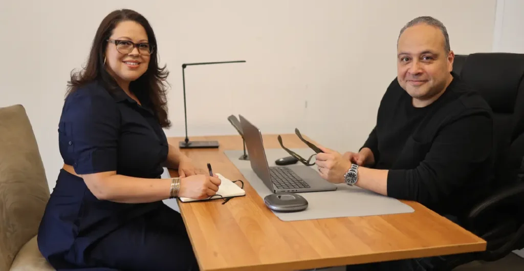 Ada and George Rosales, BOUNCE founders, working together at a desk on workforce marketing strategy.